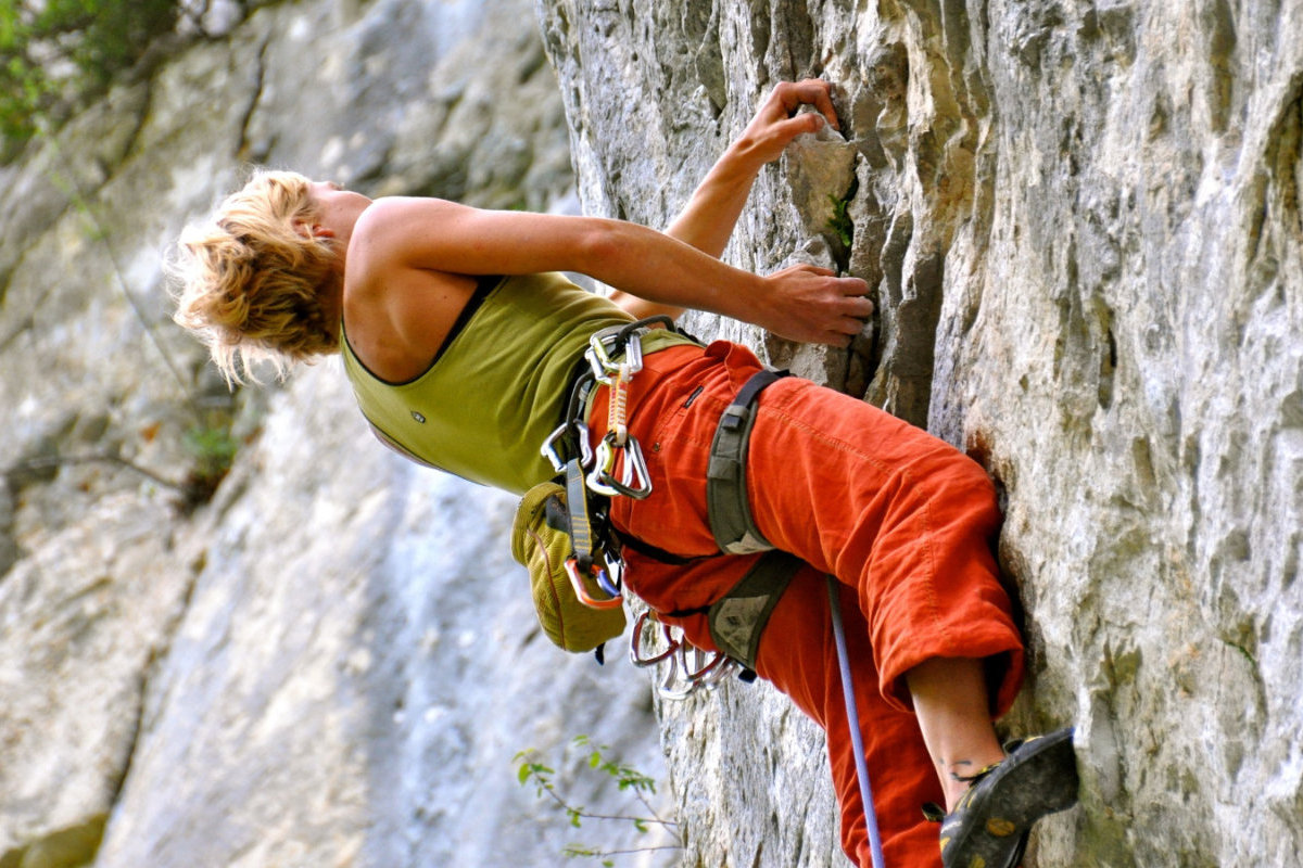 Femme escaladant un mur naturel
