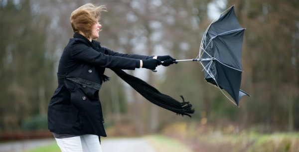 Femme avec parapluie renversé par le vent
